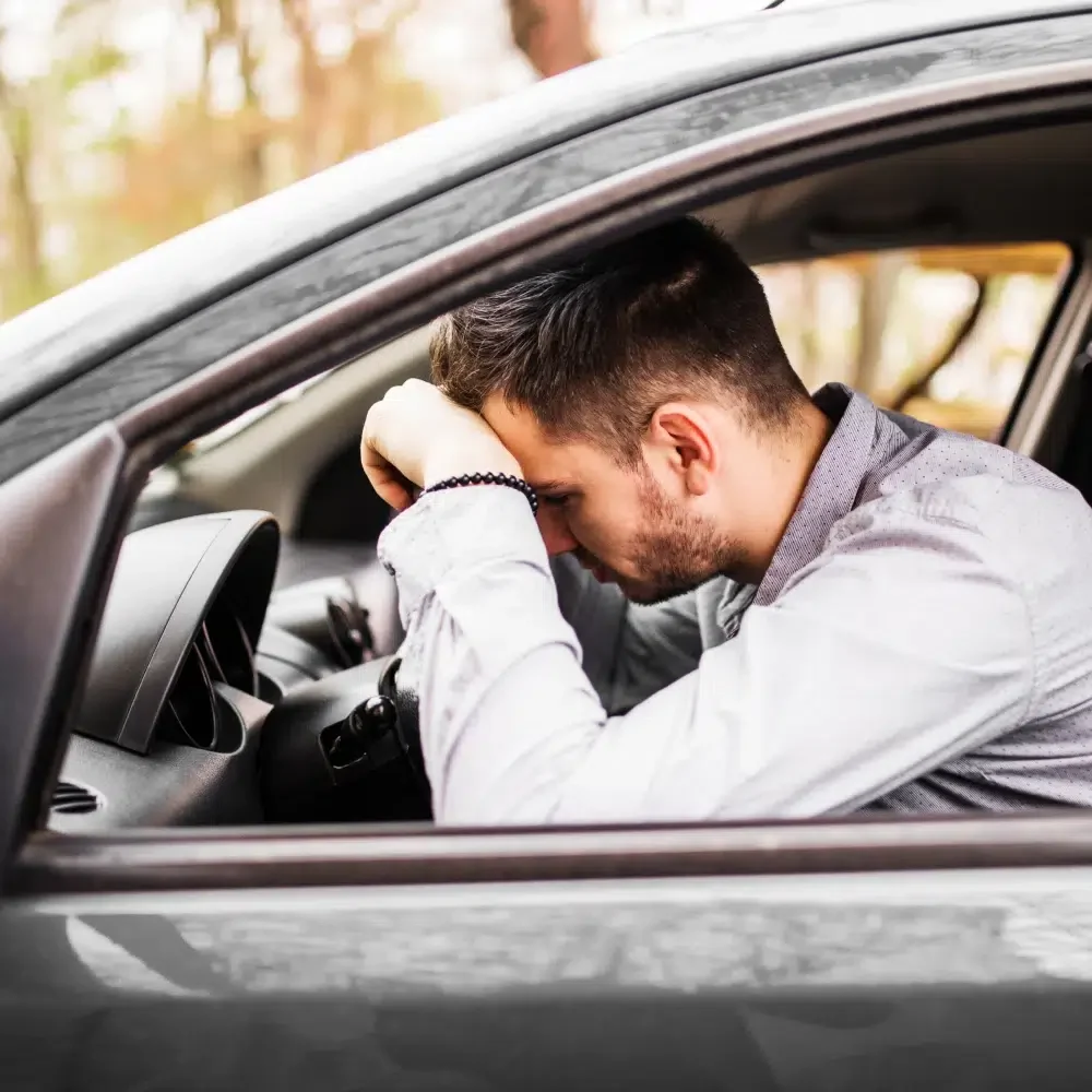 young_man_sitting_car_very_upset_stressed_after_hard_failure_moving_traffic_jam_1